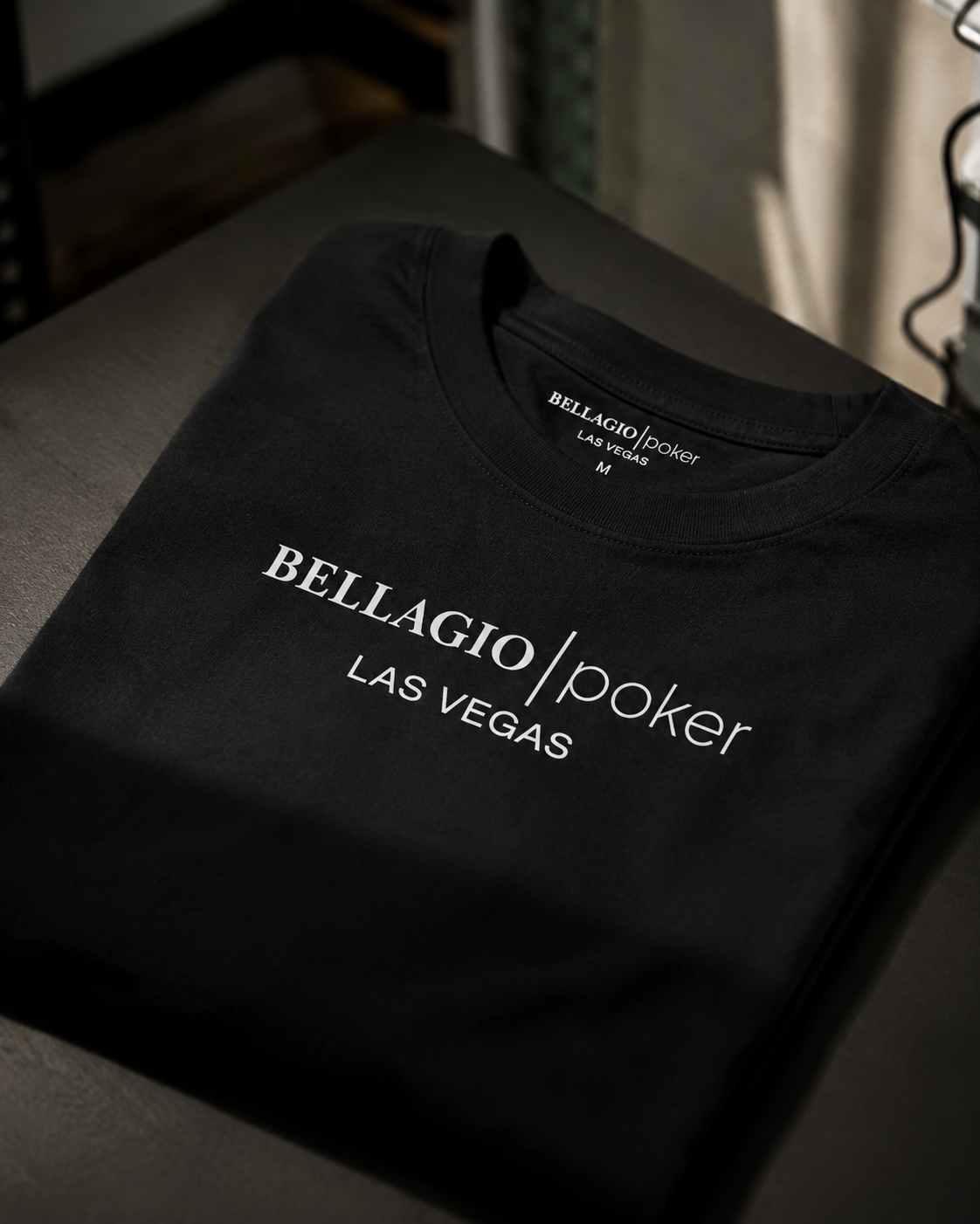 Folded black t-shirt printed with Bellagio Poker Las Vegas design, produced by 4Winners Merch